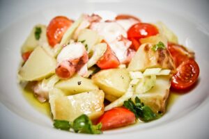 Теплый салат из осьминогов с помидорами-черри и отварным картофелем